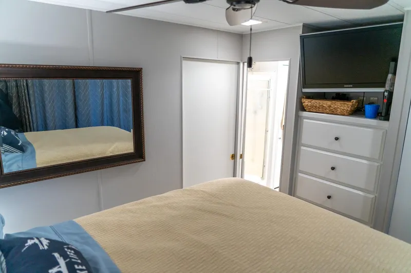 Slide: The Image of Bedroom interior of 1996 Lakeview houseboat with mirror, TV, and drawers. - 67