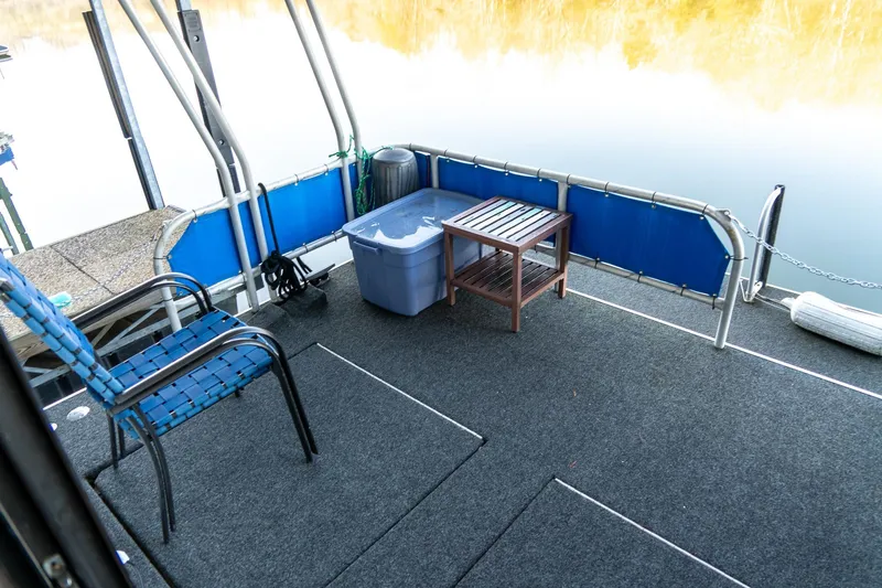 Slide: The Image of Houseboat deck with chairs, table, and storage bin on calm water. Lakeview 66 x 16 Widebody, 1996. - 70