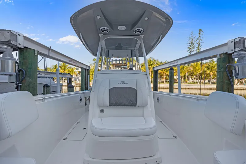 Slide: The Image of 2023 Cobia 301 Center Console boat docked, showcasing sleek design and spacious seating. - 18