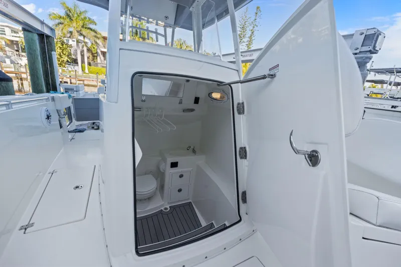 Slide: The Image of 2023 Cobia 301 Center Console boat with open cabin door, showing interior amenities. - 21