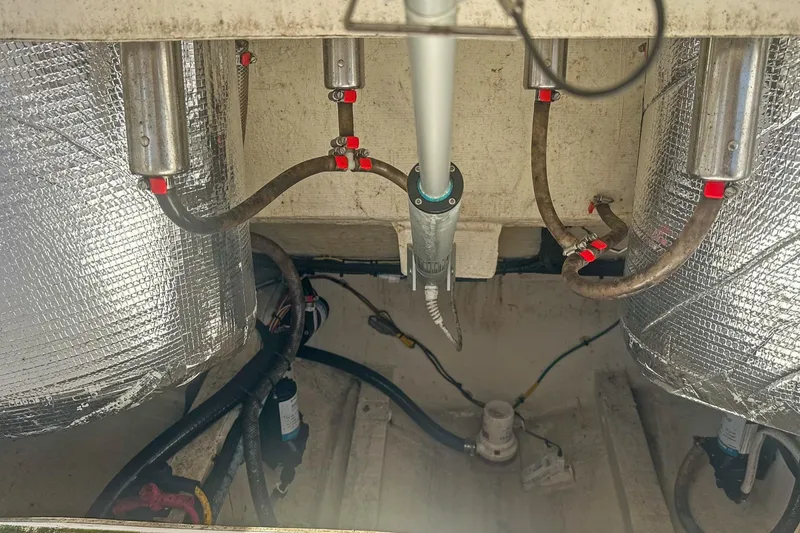 Slide: The Image of 2023 Cobia 301 Center Console boat engine compartment with insulated components and hoses. - 25