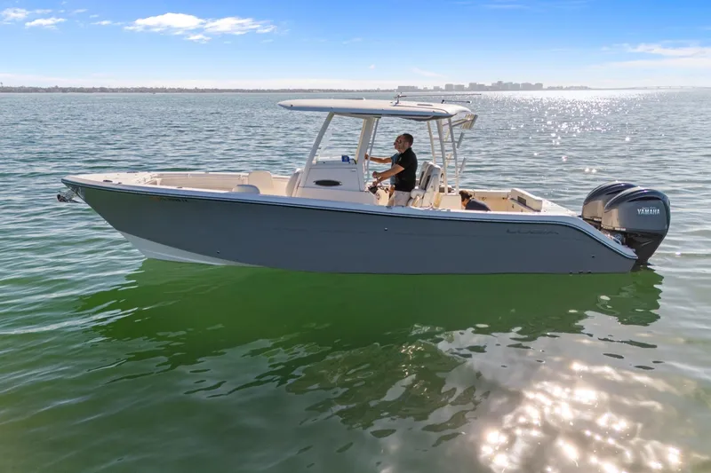 Slide: The Image of 2023 Cobia 301 Center Console boat on calm water, sunny day. - 3
