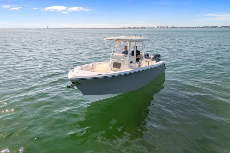 Slide: The Image of 2023 Cobia 301 Center Console boat on calm ocean waters under clear blue sky. - 4