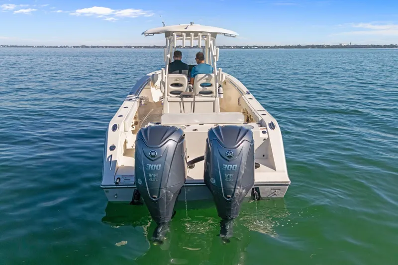 Slide: The Image of 2023 Cobia 301 Center Console boat with dual Yamaha engines on open water. - 6
