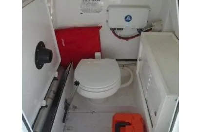 Slide: The Image of 2021 Sportsman Open 252 Center Console boat interior with toilet and storage. - 10