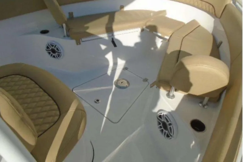 Slide: The Image of 2021 Sportsman Open 252 Center Console boat on trailer, parked near coastal homes. - 2