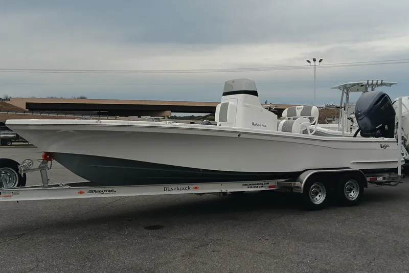 Slide: The Image of 2026 BlackJack 256 Bay boat on trailer, side view, overcast sky background. - 6