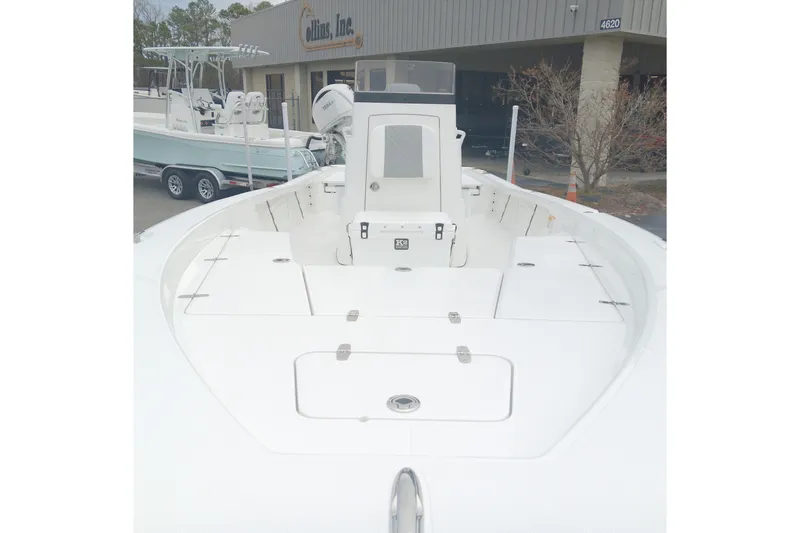 Slide: The Image of 2026 BlackJack 256 Bay boat with spacious deck and modern design, parked outside dealership. - 9
