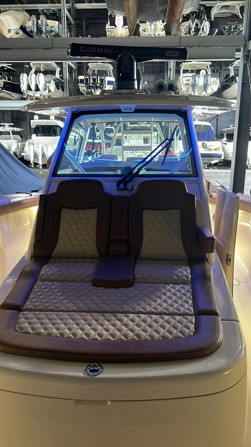 Slide: The Image of 2021 Scout LXF boat with cushioned seating, docked in a marina. - 12
