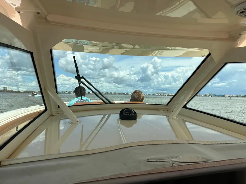 Slide: The Image of View from inside a 2021 Scout LXF boat, overlooking a scenic waterway. - 14