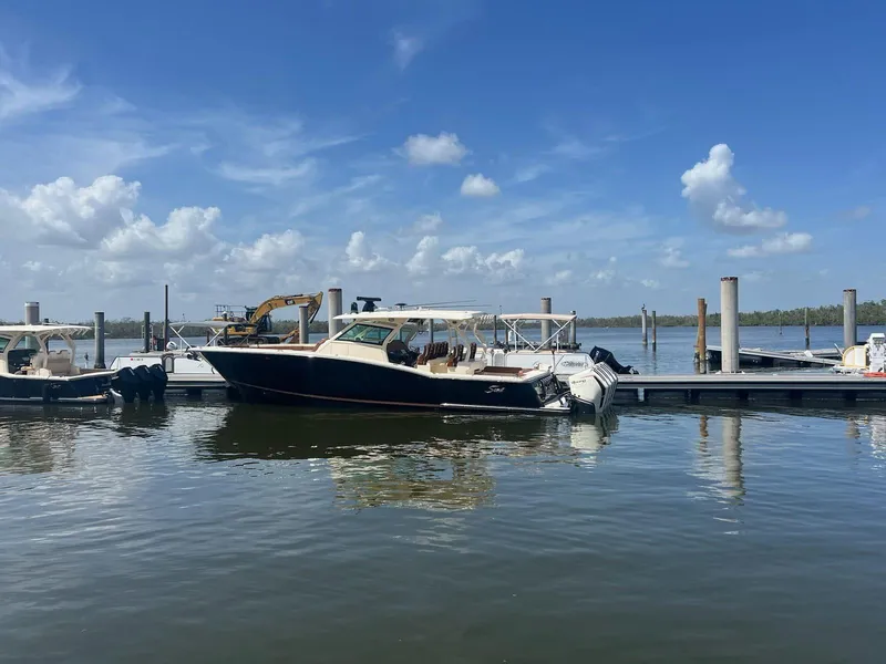 Slide: The Image of 2021 Scout LXF boat docked at marina under clear blue sky. - 2