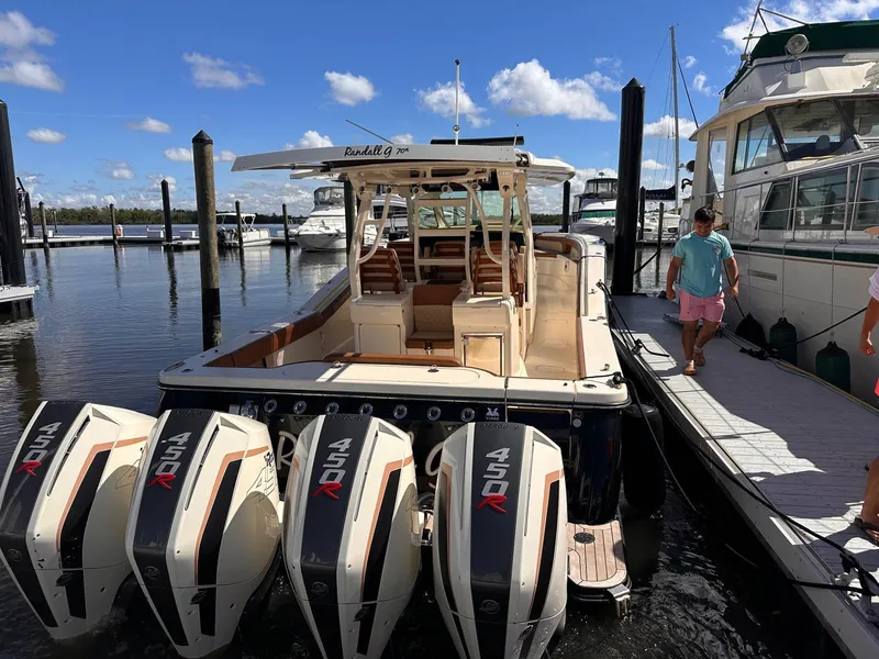 Slide: The Image of 2021 Scout LXF boat with four powerful engines docked at a marina. - 6