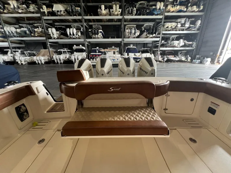 Slide: The Image of 2021 Scout LXF boat interior with brown seating, docked in a storage facility. - 9