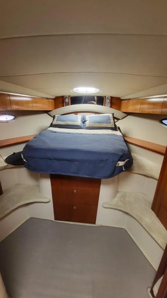 Slide: The Image of 2008 Cruisers 420 Express cabin interior with bed and wooden accents. - 14