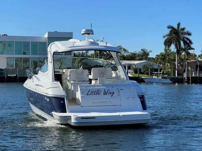 Slide: The Image of 2008 Cruisers 420 Express yacht on water, rear view, sunny day, palm trees in background. - 2