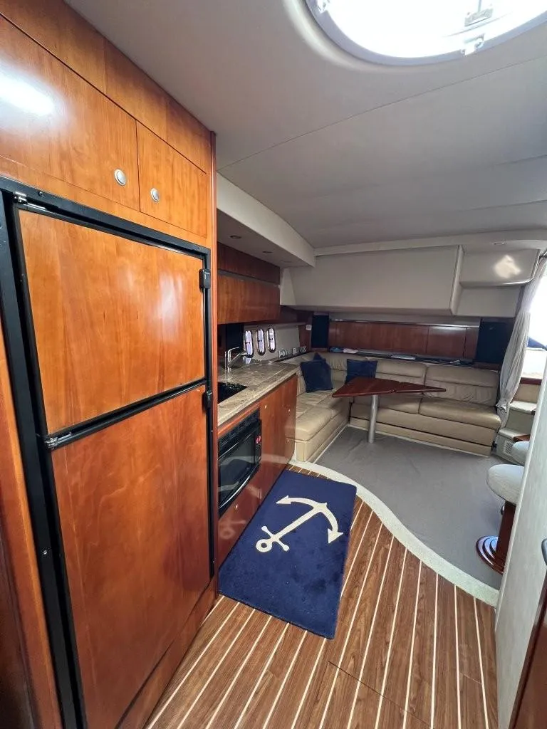 Slide: The Image of 2008 Cruisers 420 Express yacht interior with kitchen, seating area, and wooden flooring. - 12