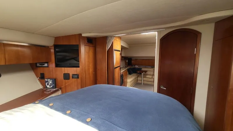 Slide: The Image of 2008 Cruisers 420 Express interior with wood finish, bed, TV, and kitchenette. - 15