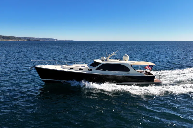 Slide: The Image of 2015 Palm Beach Motor Yachts PB45 cruising on open water under clear blue skies. - 19
