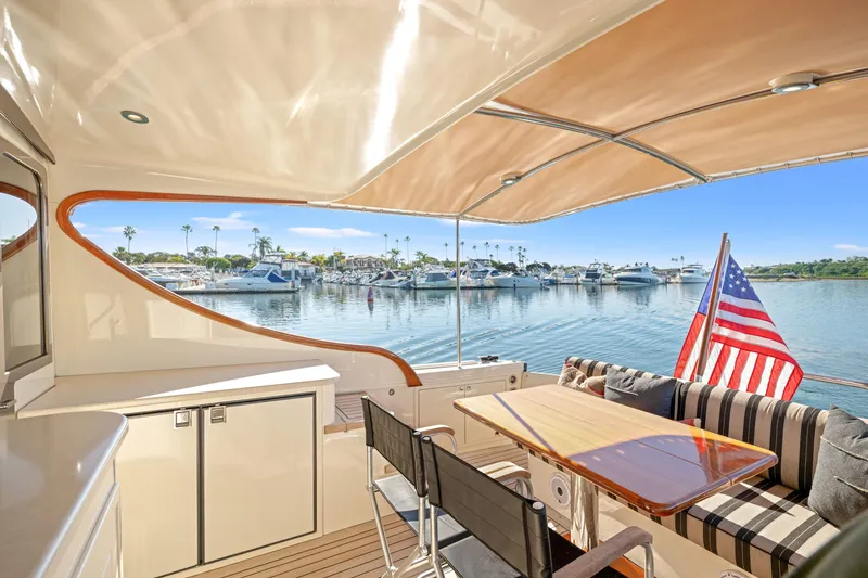 Slide: The Image of Luxurious 2015 Palm Beach Motor Yachts PB45 interior with marina view and American flag. - 28