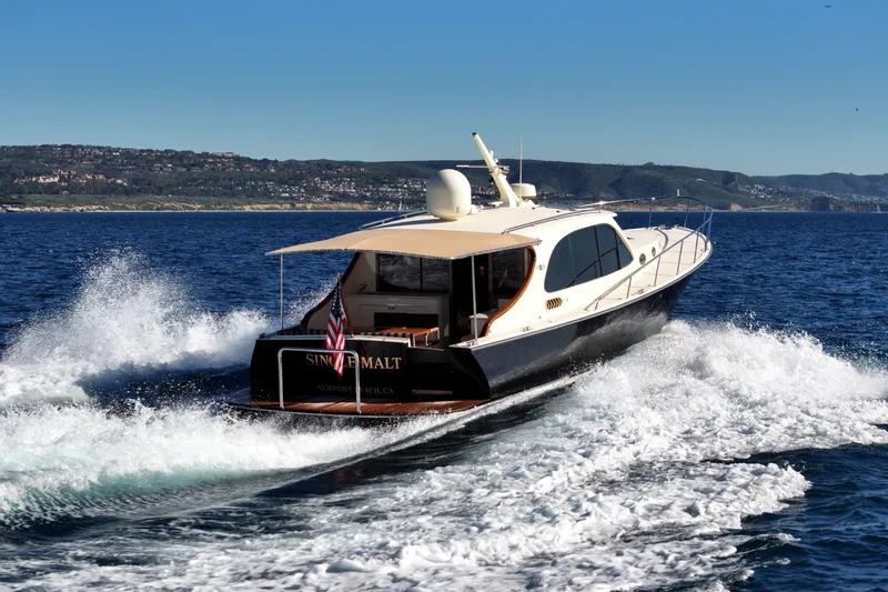Slide: The Image of 2015 Palm Beach Motor Yachts PB45 cruising on open water, scenic coastal backdrop. - 3