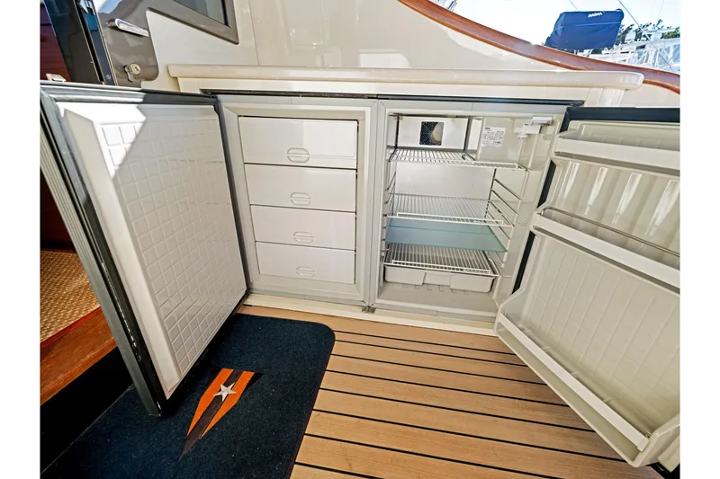 Slide: The Image of Open refrigerator and freezer on 2015 Palm Beach Motor Yachts PB45, showcasing storage compartments. - 30