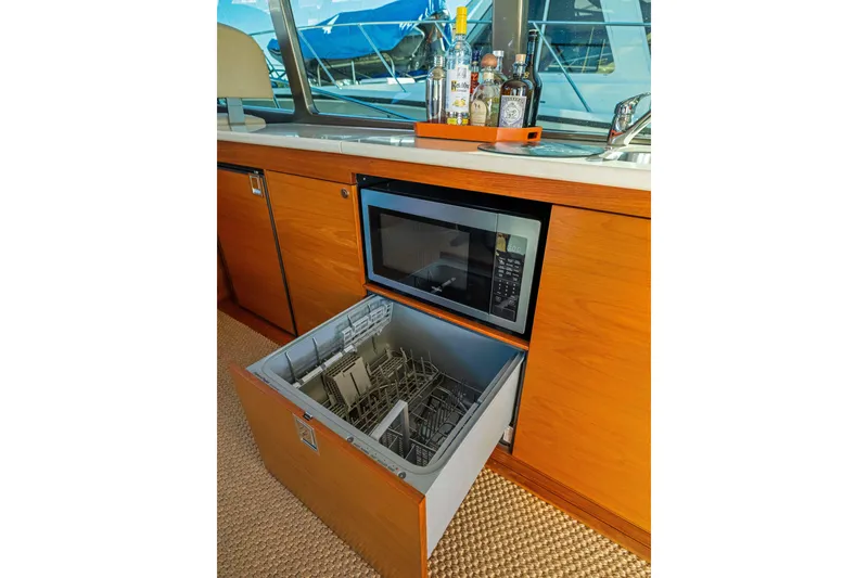 Slide: The Image of 2015 Palm Beach Motor Yachts PB45 kitchen with microwave and open dishwasher drawer. - 36
