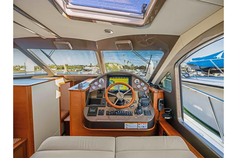 Slide: The Image of 2015 Palm Beach Motor Yachts PB45 helm with wooden steering wheel and navigation instruments. - 43
