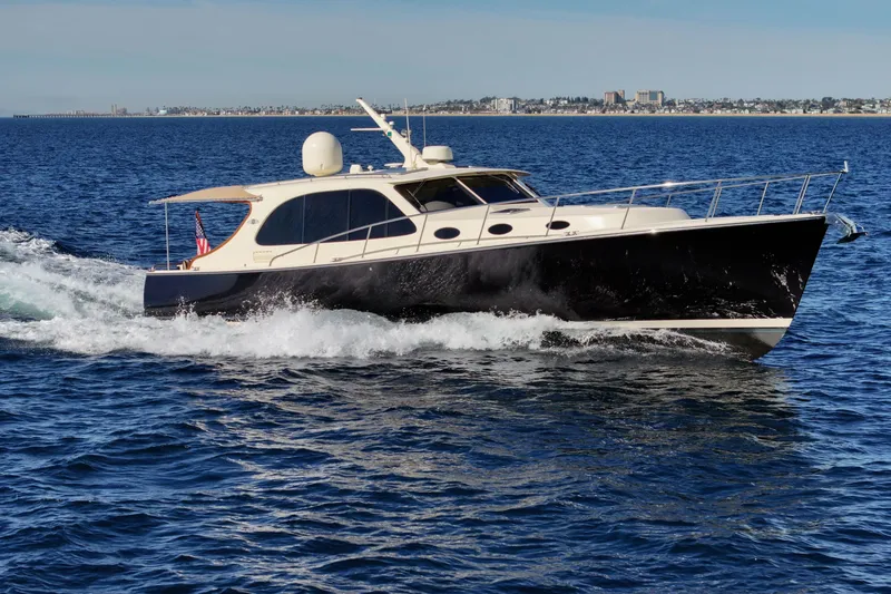 Slide: The Image of 2015 Palm Beach Motor Yachts PB45 cruising on open water, cityscape in background. - 9
