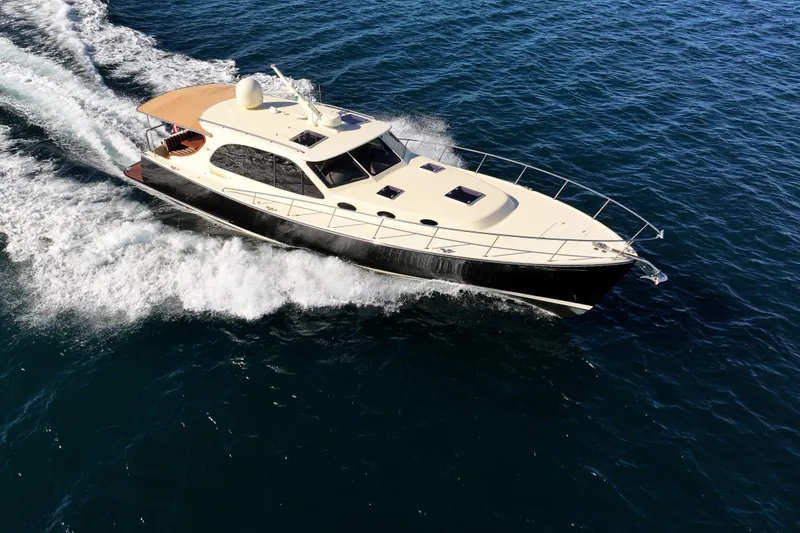 Slide: The Image of 2015 Palm Beach Motor Yachts PB45 cruising on open water, showcasing sleek design and performance. - 14