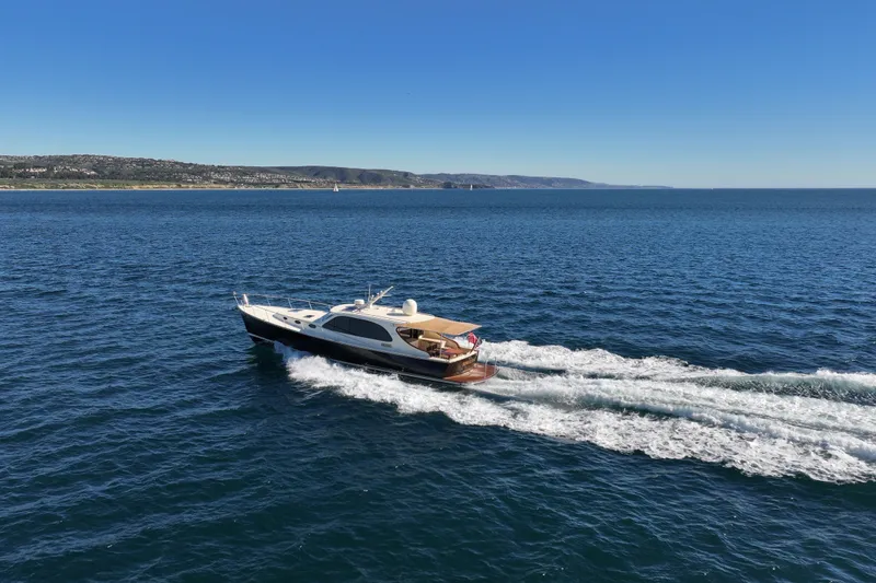 Slide: The Image of 2015 Palm Beach Motor Yachts PB45 cruising on open sea under clear blue sky. - 16