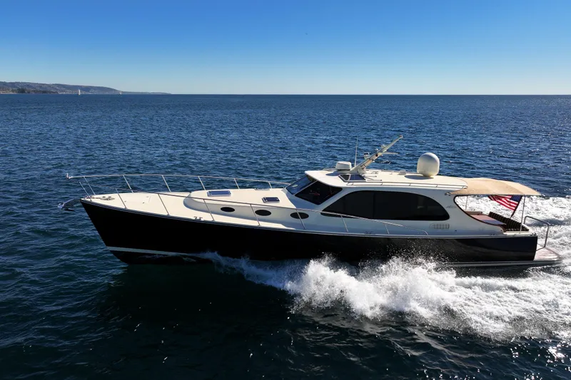 Slide: The Image of 2015 Palm Beach Motor Yachts PB45 cruising on open water under clear blue sky. - 18