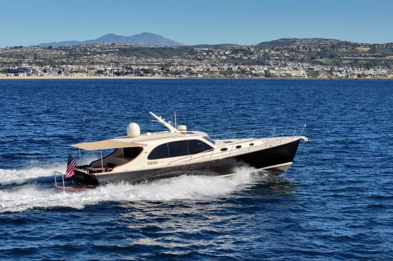 Slide: The Image of 2015 Palm Beach Motor Yachts PB45 cruising on blue ocean with coastal backdrop. - 2