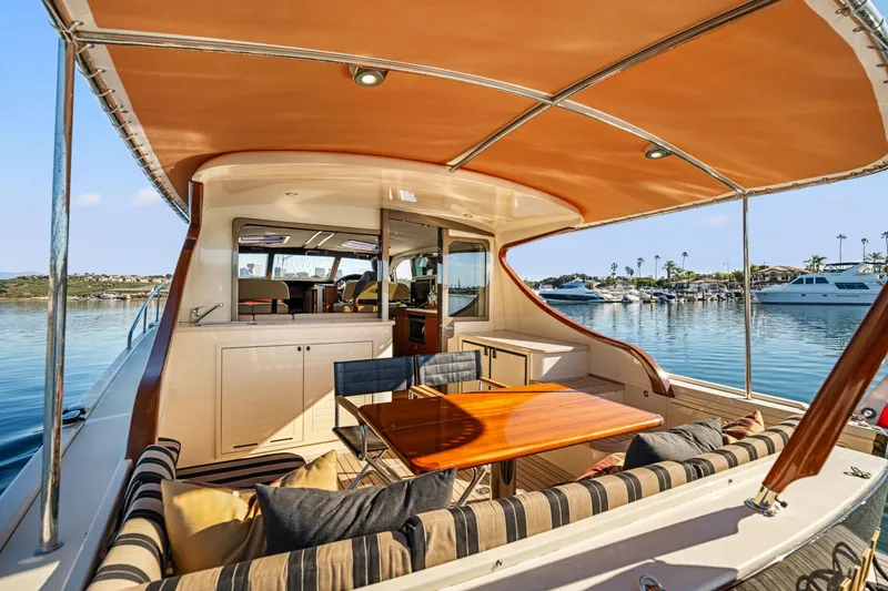 Slide: The Image of 2015 Palm Beach Motor Yachts PB45 interior with elegant seating and table, docked at marina. - 27