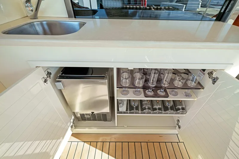 Slide: The Image of 2015 Palm Beach Motor Yachts PB45 interior with sink, glassware, and storage cabinet. - 32