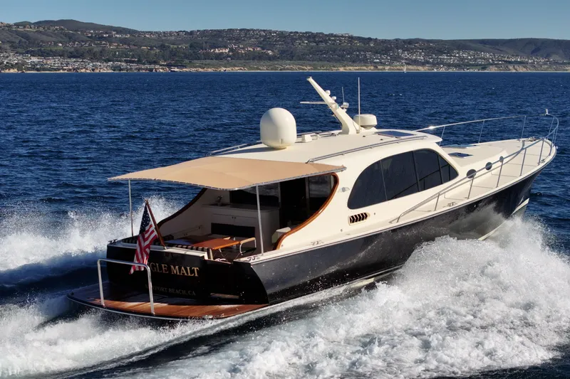 Slide: The Image of 2015 Palm Beach Motor Yachts PB45 cruising on open water, scenic coastal backdrop. - 4