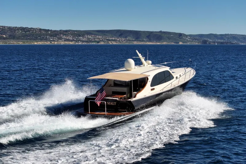 Slide: The Image of 2015 Palm Beach Motor Yachts PB45 cruising on open water, scenic coastal backdrop. - 5