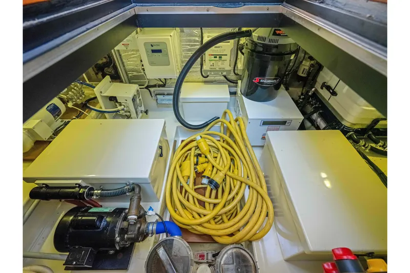 Slide: The Image of Engine room of 2015 Palm Beach Motor Yachts PB45 with equipment and yellow cables. - 59
