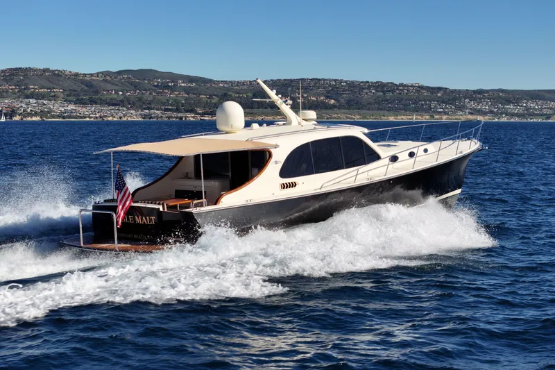 Slide: The Image of 2015 Palm Beach Motor Yachts PB45 cruising on open water, scenic coastal backdrop. - 6
