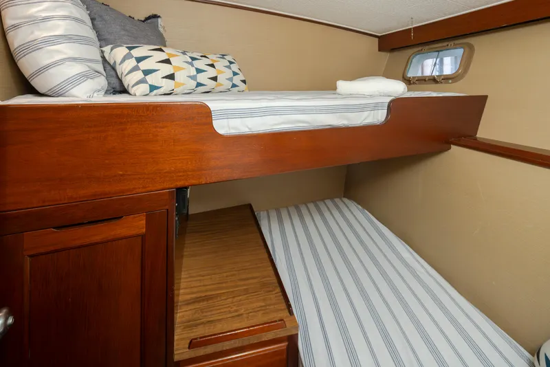 Slide: The Image of 1965 Stephens Flushdeck cabin with bunk beds and striped bedding. - 37