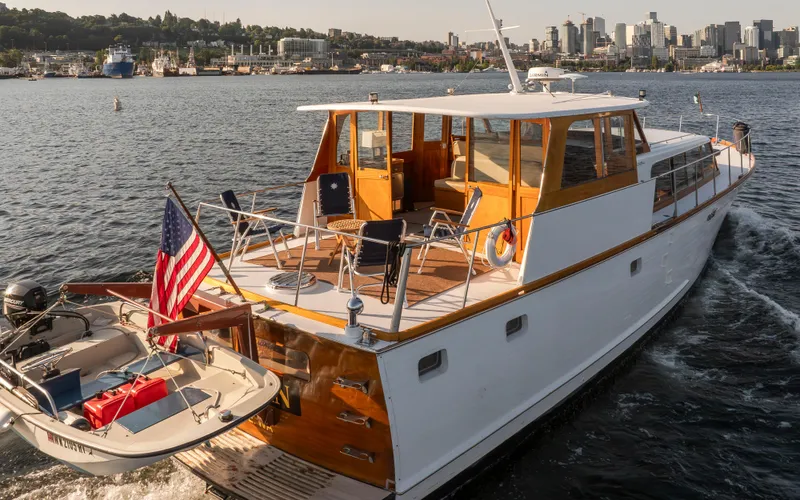 Slide: The Image of 1965 Stephens Flushdeck yacht on water with dinghy and flag. - 4