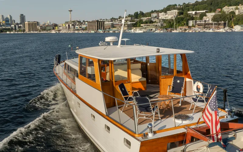 Slide: The Image of 1965 Stephens Flushdeck yacht cruising near Seattle skyline. - 7