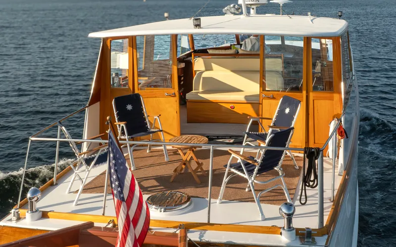Slide: The Image of 1965 Stephens Flushdeck yacht on water, featuring chairs and American flag. - 9