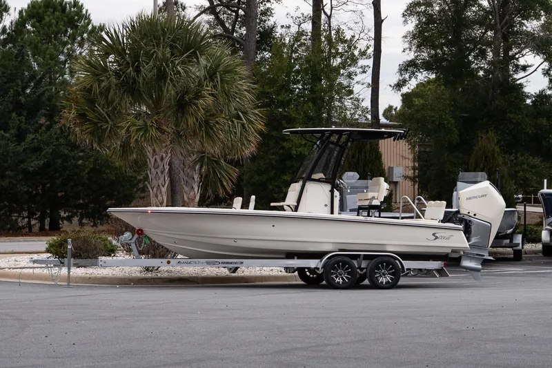 The Image of 2026 Scout 231 XSB boat on trailer, parked near palm trees. - 1