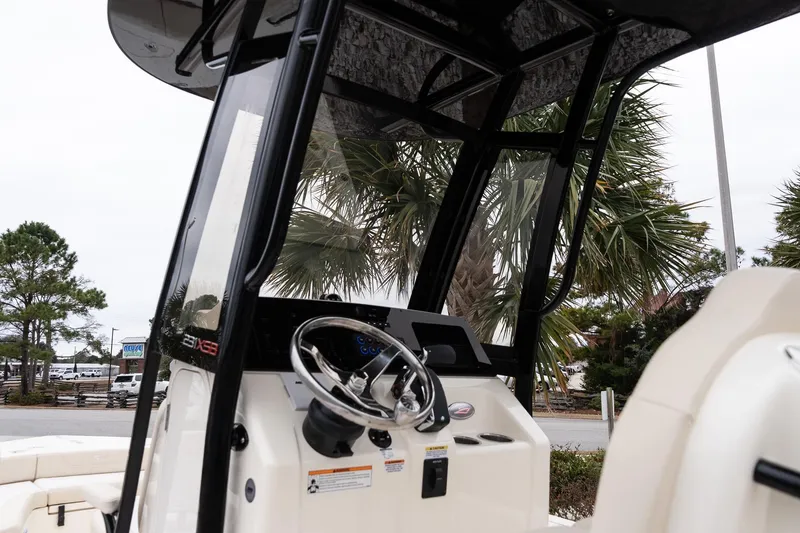 Slide: The Image of 2026 Scout 231 XSB boat console with steering wheel and palm trees in background. - 16