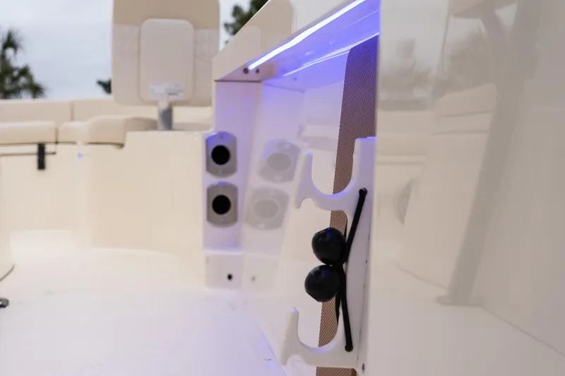Slide: The Image of 2026 Scout 231 XSB boat interior with rod holders and blue LED lighting. - 20