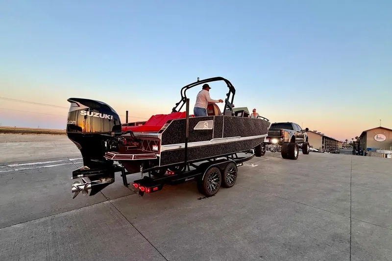 The Image of 2026 Anthem Assault VF23 boat on trailer, sunset background, Suzuki engine visible. - 0