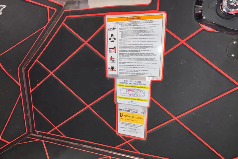 Slide: The Image of Warning and capacity labels on Anthem Assault VF23, 2026 model, with red geometric design. - 16