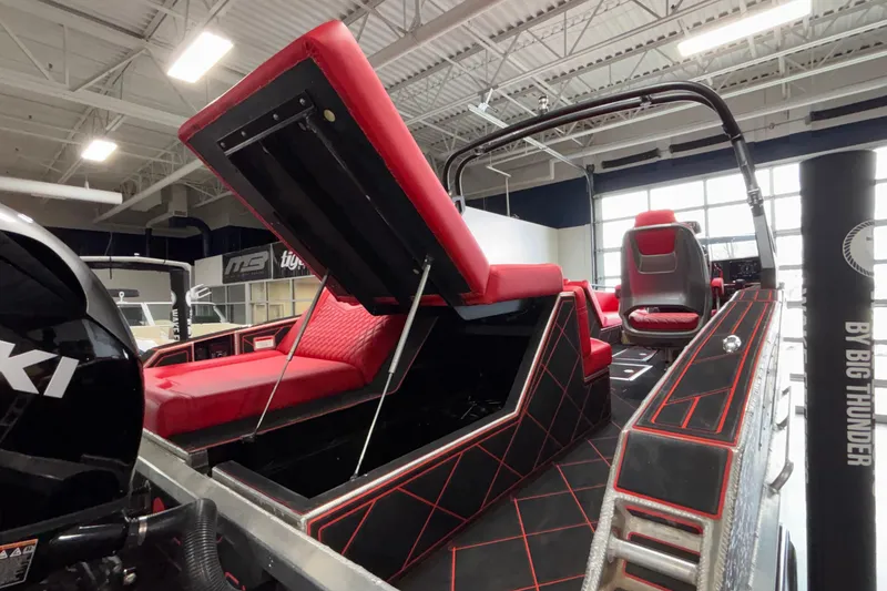 Slide: The Image of 2026 Anthem Assault VF23 boat interior with red and black seating, open storage compartment. - 18