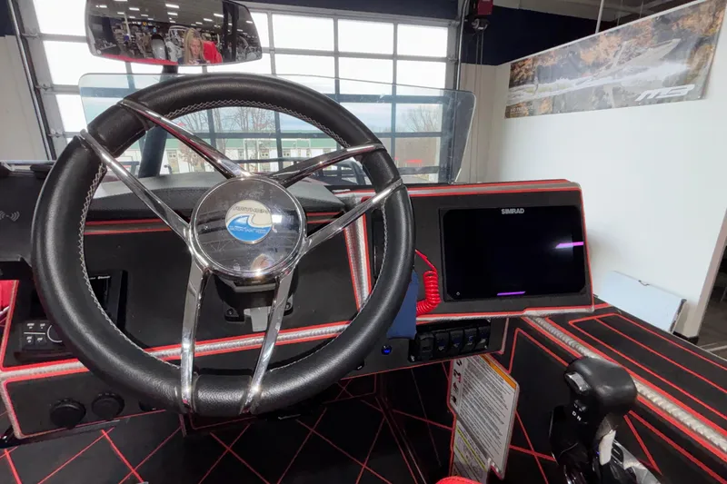 Slide: The Image of Interior view of 2026 Anthem Assault VF23 boat cockpit with steering wheel and Simrad display. - 2