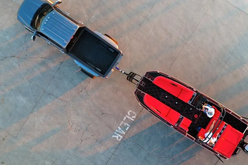 Slide: The Image of Aerial view of Anthem Assault VF23 truck towing a red boat on concrete surface. - 32